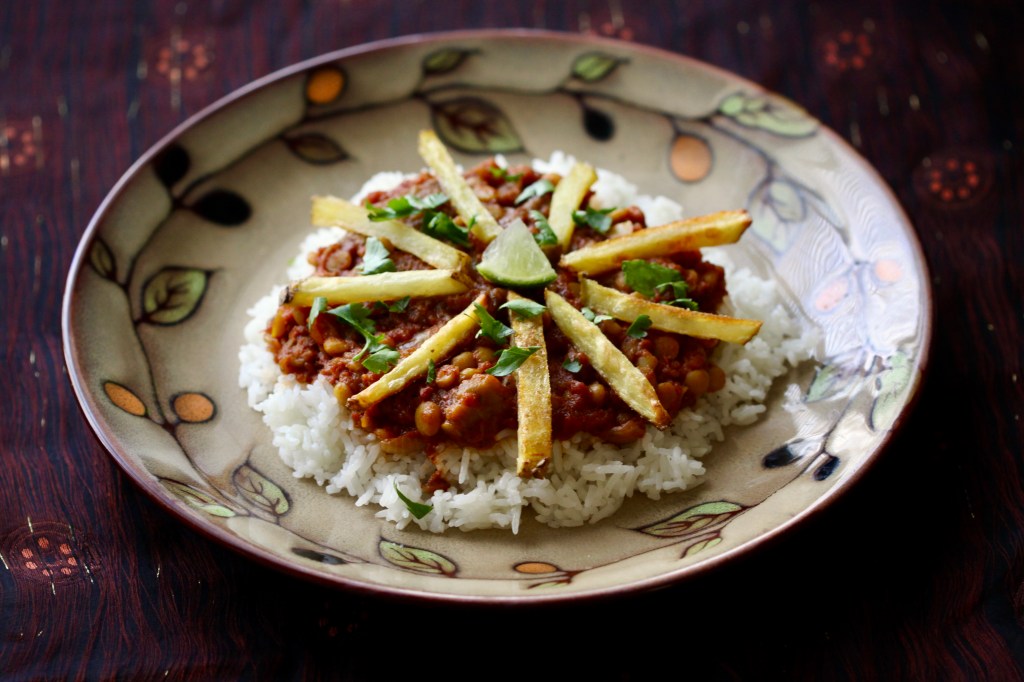 Stew over rice with french fries on top