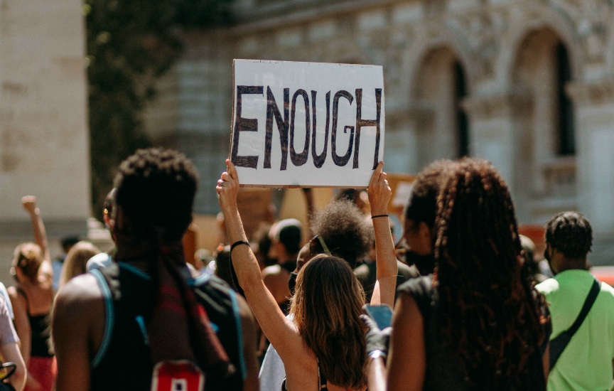 A protestor holds a sign saying "ENOUGH"