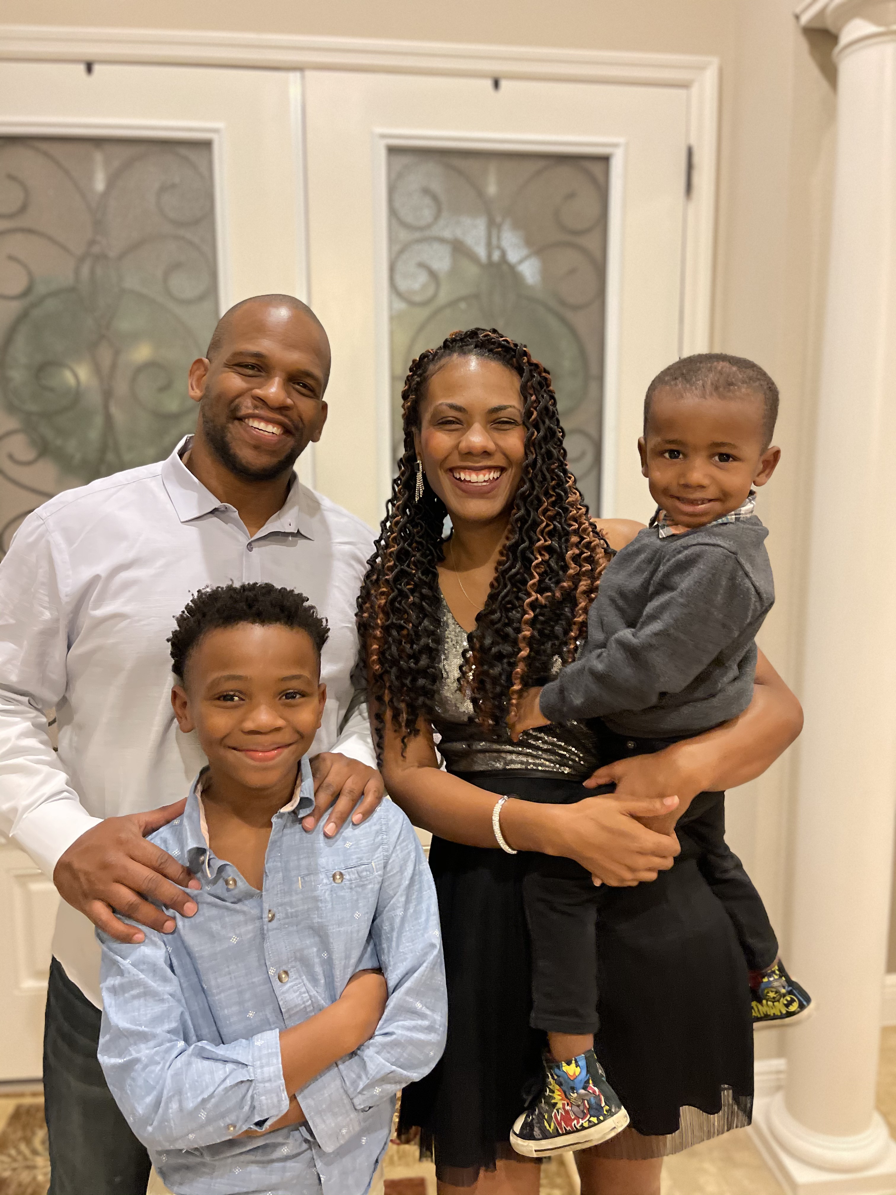 A family portrait with a father, mother, adolescent son, and baby son.