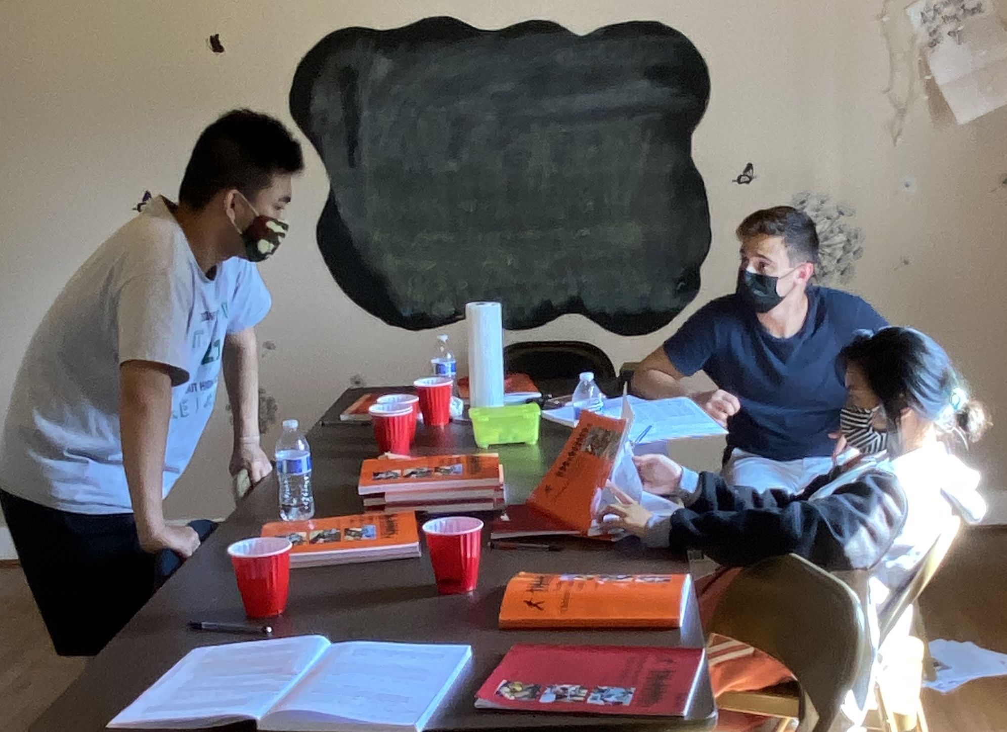 Three teenagers study together in a conference room.