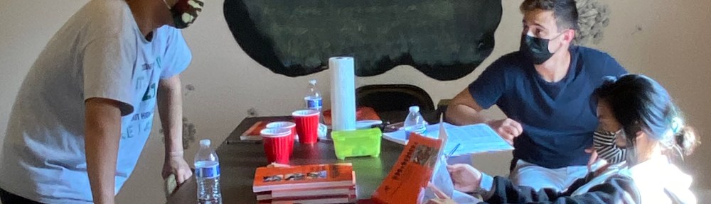 Three teenagers study together in a conference room.