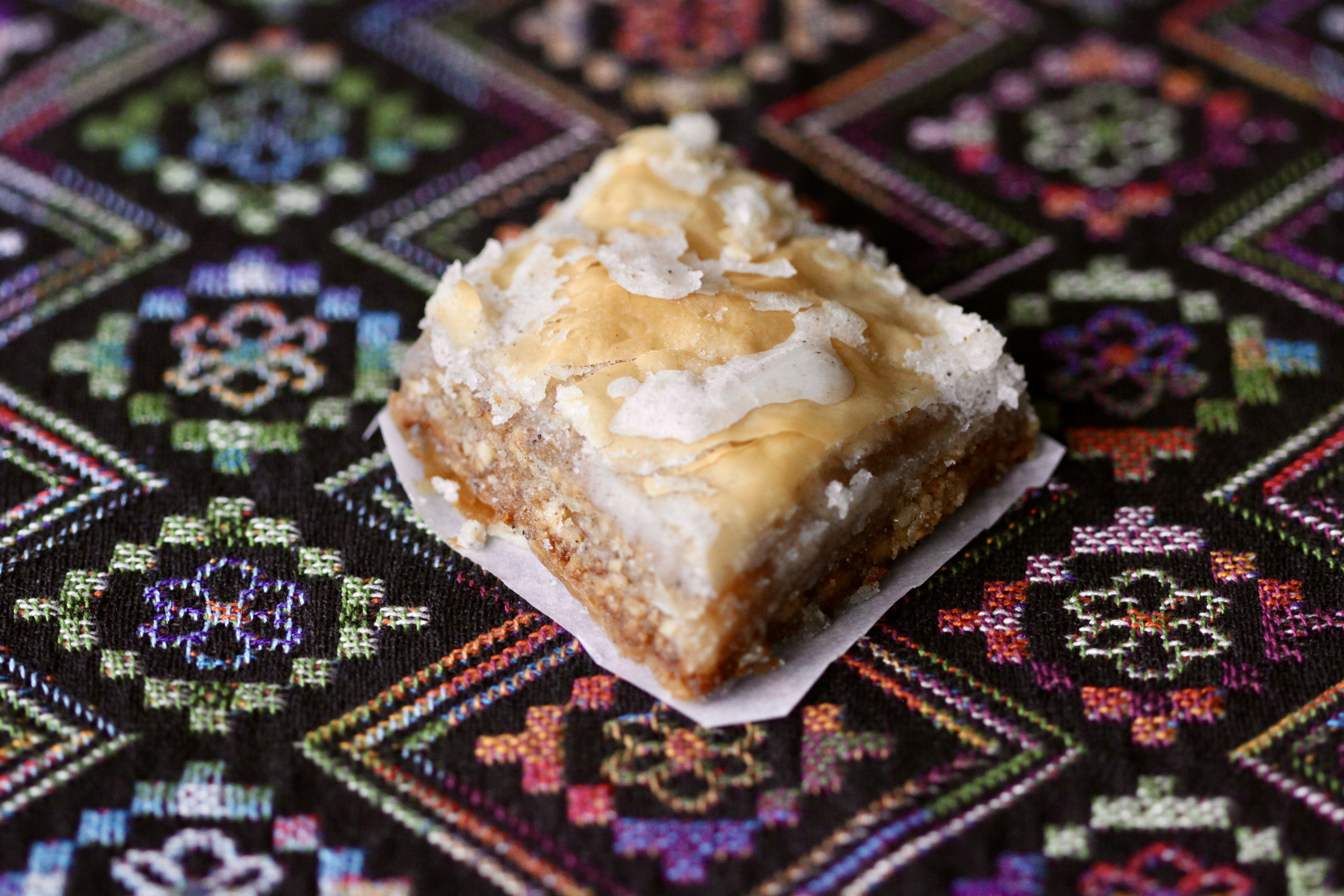 A diamond-shaped pastry on top of patterned cloth.