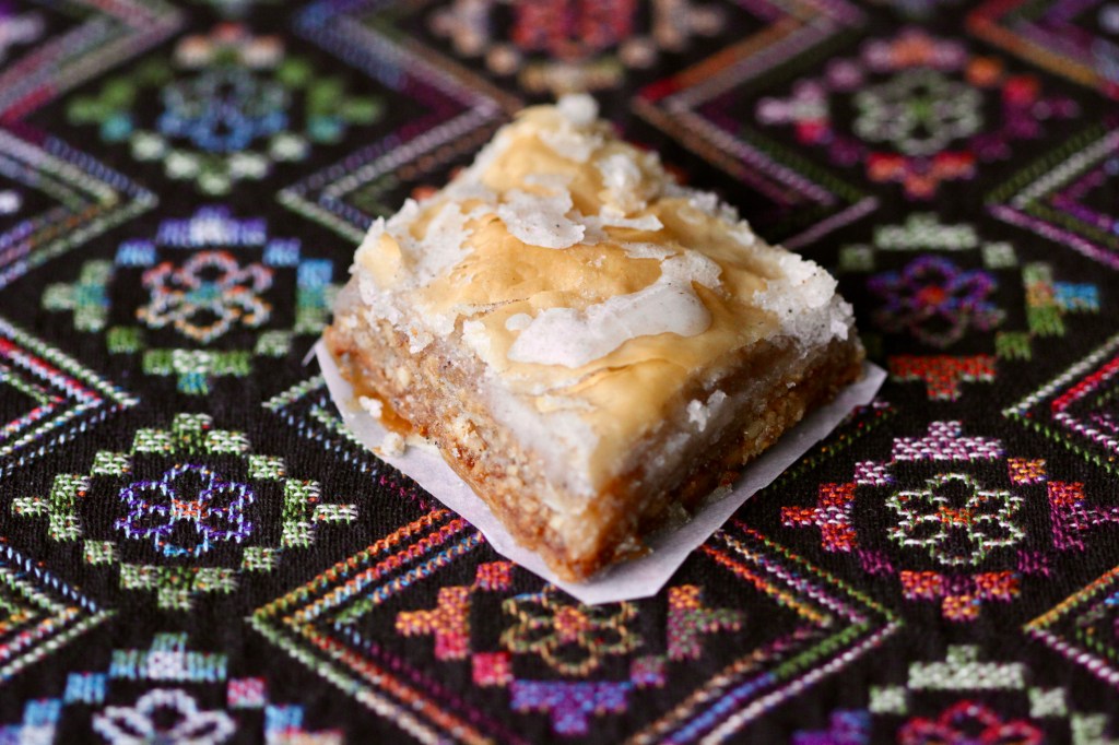 A diamond-shaped pastry on top of patterned cloth.