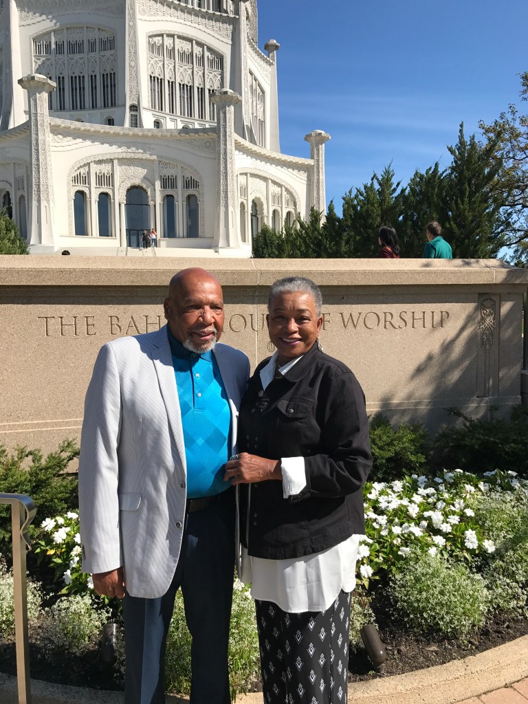 A couple poses in front of a Baha'i temple.