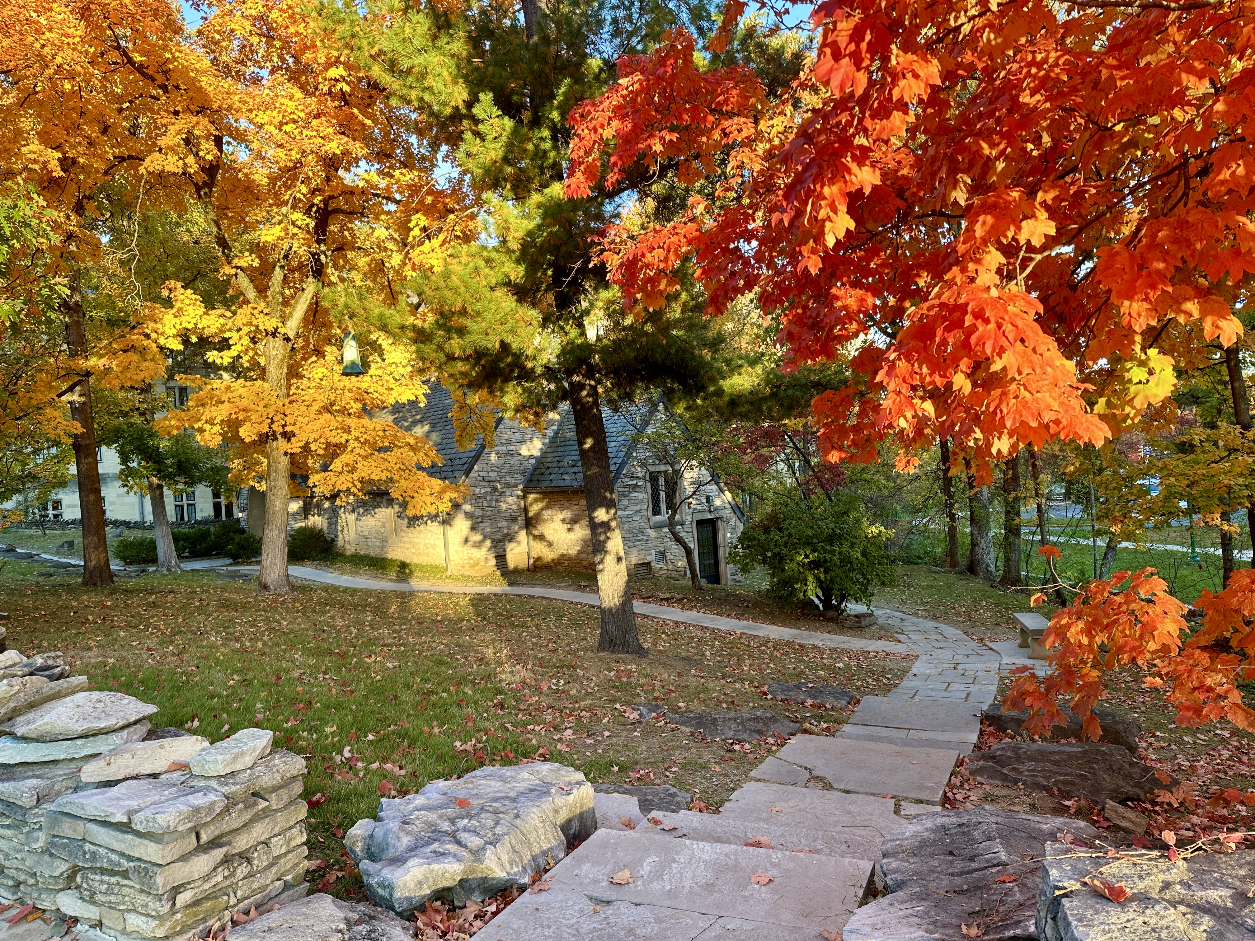 A limestone chapel peeks out from behind autumn foliage.