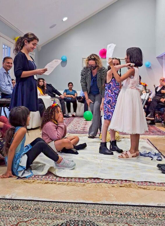 A group of kids plays a game guided by a few adults. 