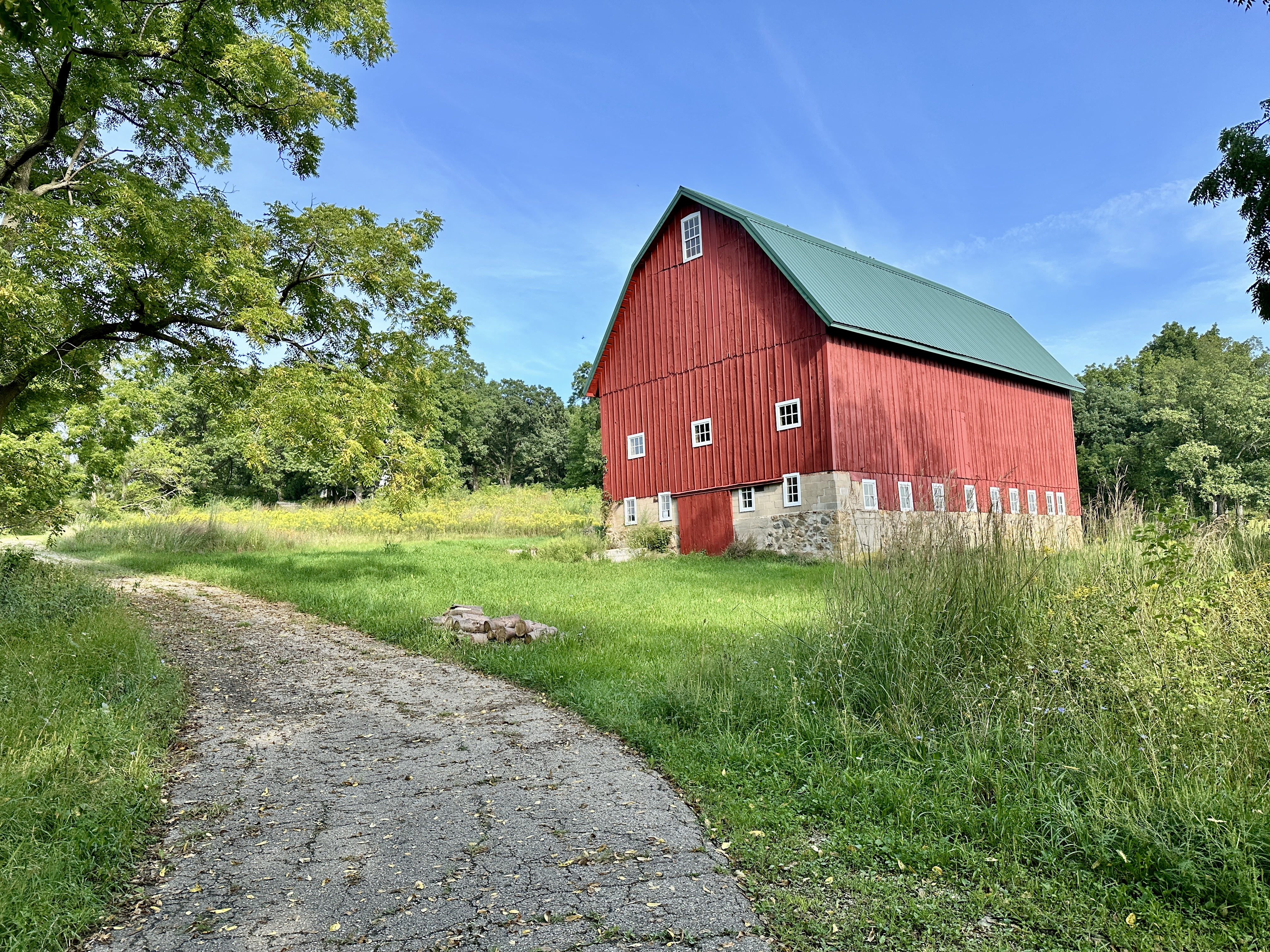 A red barn beside a paved path.