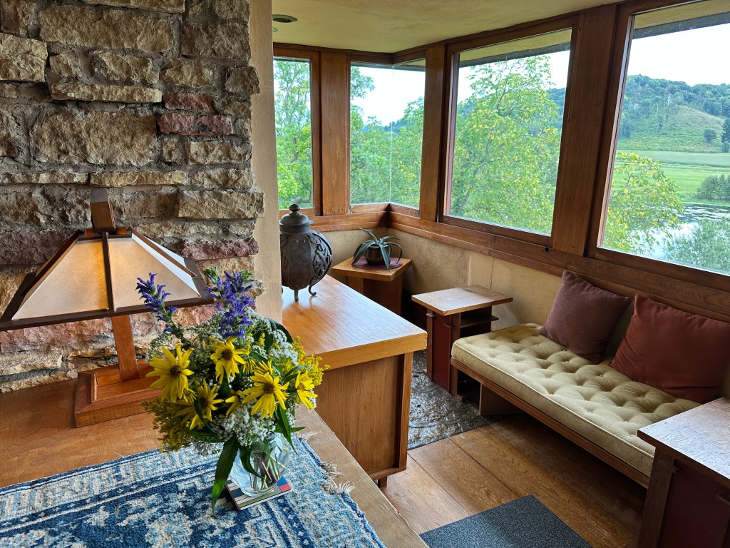 An elegant living room with large windows overlooking countryside.